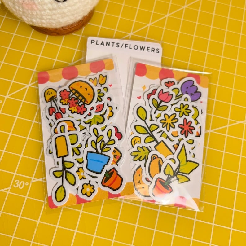 May include: Two sheets of stickers featuring colourful illustrations of plants, flowers, and gardening tools. The stickers are packaged in clear plastic and labelled "PLANTS/FLOWERS".