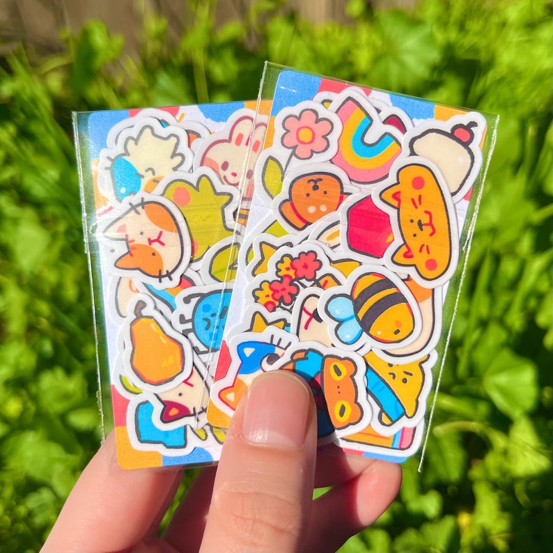 May include: A sheet of colourful stickers featuring cute cartoon animals, insects, and flowers. The stickers are perfect for adding a touch of whimsy to journals, planners, and other craft projects.