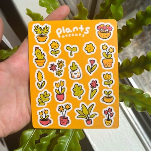 Puede incluir: Una hoja de pegatinas con varias ilustraciones de plantas sobre un fondo naranja. Las pegatinas incluyen plantas en macetas, flores y hojas, con caras sonrientes. El texto "plants ayeoops" está en la parte superior.