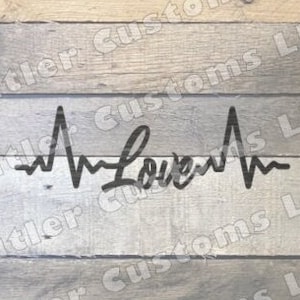 May include: Black and white graphic design of a heartbeat with the word "Love" in the centre. The design is on a wood background.