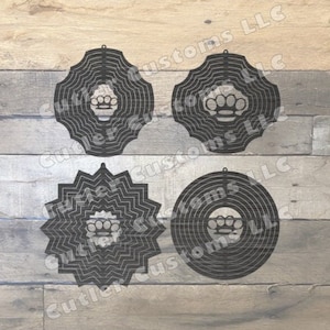 May include: Four black metal wind spinners featuring a knuckle duster design. The spinners are layered and circular in shape.