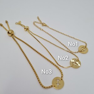 May include: Three gold adjustable bracelets with different zodiac signs. The first bracelet has the symbol for Cancer, the second bracelet has the symbol for Virgo, and the third bracelet has the symbol for Sagittarius.