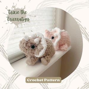 May include: Two handmade crochet triceratops dinosaurs in the image. One is light brown with white accents, and the other is pink with white accents. The text "Trixie the Triceratops" and "Crochet Pattern" are also visible.