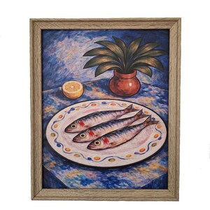 May include: A framed painting depicts a still life with three fish on a decorative plate. A potted plant and a lemon half sit on a blue tablecloth. The artwork is in a wooden frame.