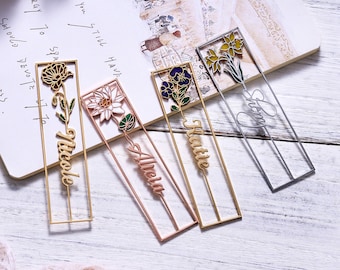 May include: Four gold metal bookmarks with floral designs and personalized names. The names are "Nicole", "Allela", "Hattie", and "Shay".