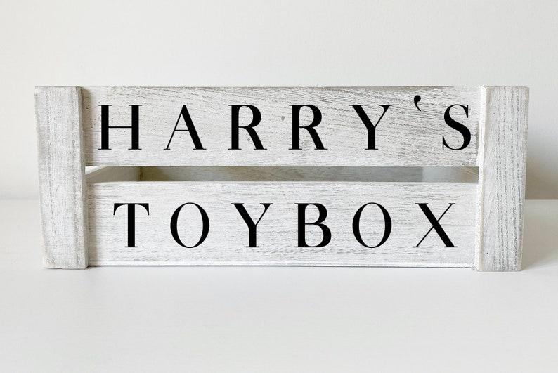 K&ouml;nnte beinhalten: Wei&szlig;e Holzspielzeugkiste mit schwarzer Beschriftung "HARRY'S TOYBOX".