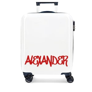 以下が含まれることがあります： 赤い「ALEXANDER」ネームタグが付いた白いスーツケース