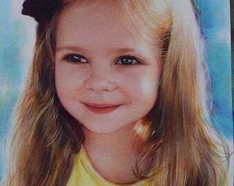 May include: A realistic colored pencil drawing of a young child with long blonde hair and a dark bow. The child wears a bright yellow shirt and has a soft smile. The background features blended strokes of blue and white, with a signature in the corner.