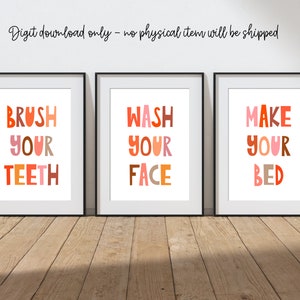 May include: Three framed art prints with the phrases "BRUSH YOUR TEETH", "WASH YOUR FACE", and "MAKE YOUR BED" in colorful, block letters. The prints are in black frames and are displayed on a wooden floor. The text "Digit download only - no physical item will be shipped" is above the prints.