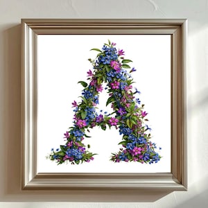 May include: A square silver frame containing a white print of the letter A, which is formed entirely from a dense arrangement of small blue and magenta flowers with green leaves, creating a botanical floral alphabet letter design.