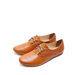 K&ouml;nnte beinhalten: Ein Paar braune Lederschuhe mit Schn&uuml;rung und niedrigem Absatz.