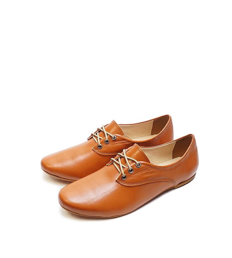K&ouml;nnte beinhalten: Ein Paar braune Lederschuhe mit Schn&uuml;rung und niedrigem Absatz.