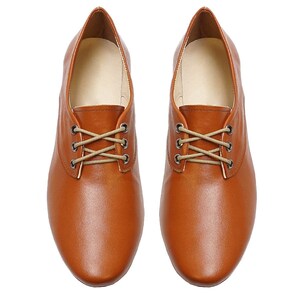 K&ouml;nnte beinhalten: Ein Paar braune Lederschuhe mit Schn&uuml;rung und abgerundeter Spitze.