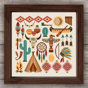 May include: A framed cross-stitch artwork with Native American motifs. The design includes a teepee, dream catcher, arrows, feathers, and a cactus, all in a geometric, colourful style. The artwork is set against a cream background and framed in a dark brown wood.