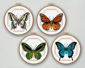 May include: Four framed cross-stitch butterfly designs. Each butterfly is displayed in a round wooden hoop with a geometric gold border. The butterflies feature various colors, including orange, blue, green, and black.