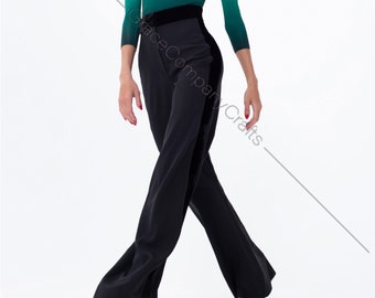May include: A woman wearing a green and black ombre top with a black velvet waistband and black wide-leg pants.