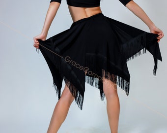 May include: A black dance costume with a fringed skirt and a black crop top. The dancer is wearing brown dance shoes.