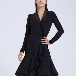 K&ouml;nnte beinhalten: Ein schwarzes Tanzkleid mit langen &Auml;rmeln, einem Wickel-Oberteil und einem gerafften Rock. Das Kleid hat einen Samtbesatz und eine Satinschleife.