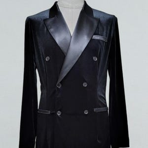 以下が含まれることがあります： サテンのラペルと4つのボタンが付いた、黒いベルベットのダブルブレストブレザー。 ブレザーには2つのフロントポケットがあり、マネキンに表示されています。 この衣服はフォーマルウェアアイテムです。