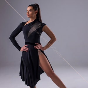 May include: A woman wearing a black dance dress with a sheer panel and a high slit. She is wearing brown dance shoes and has her hair pulled back in a ponytail.