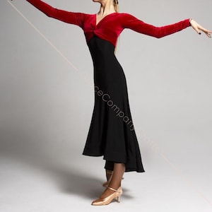 May include: A woman wearing a red velvet long-sleeved top with a black skirt. The skirt has a high waist and a flowing, asymmetrical hemline. The woman is wearing nude heels.