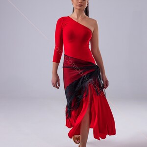 May include: A woman wearing a red one-shoulder dress with a black lace shawl and brown dance shoes.