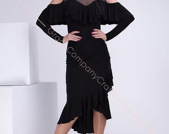 May include: A black dance dress with a ruffled neckline and long sleeves. The dress has a sheer mesh panel at the neckline and a high-low hemline. The dress is shown on a model with a white background.