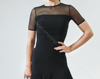 Puede incluir: Un vestido de baile negro con una parte superior de malla y una falda acampanada. El vestido tiene mangas cortas y un escote redondo.