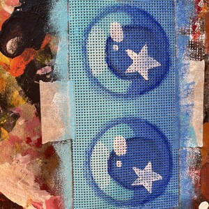 May include: A blue and white stencil with two circles containing a star and a bubble. The stencil is on a blue mesh background.