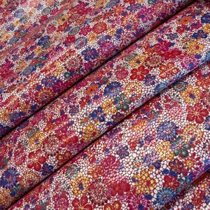 May include: A sheet of fabric featuring a dense, repeating pattern of small, multi-colored flowers in shades of red, yellow, blue, and green, layered over a white, fine-mesh, honeycomb-like grid texture that covers the entire surface.