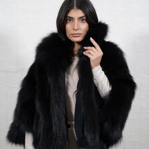 Close up detail of genuine fox fur texture showing soft premium quality pelts used in handmade artisan fur coat
