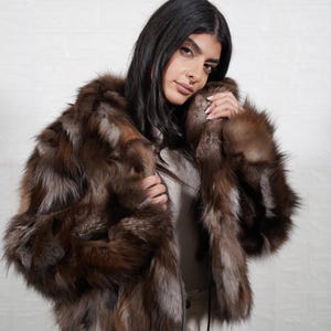 Close up detail of genuine fox fur texture showing soft premium quality pelts used in handmade artisan fur coat