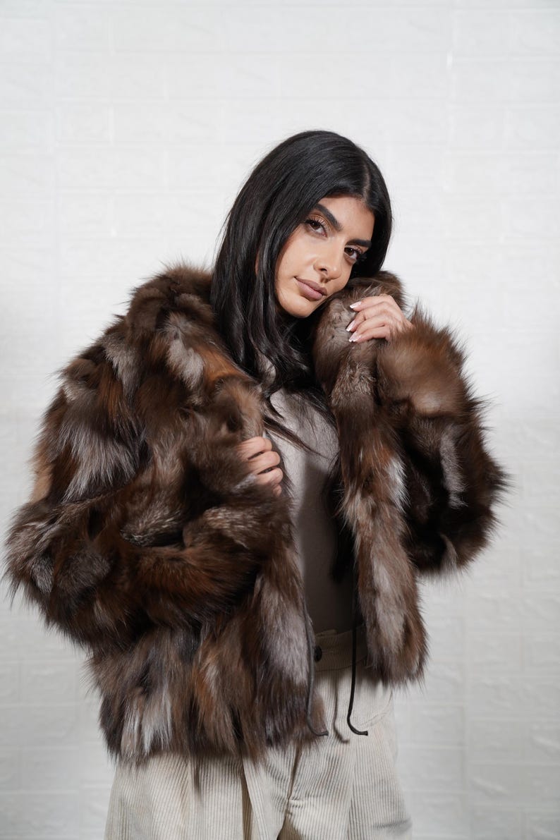 Close up detail of genuine fox fur texture showing soft premium quality pelts used in handmade artisan fur coat