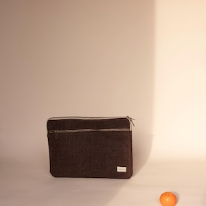 Eco-friendly hemp laptop sleeve in  Brown , designed to fit 13-inch and 15-inch laptops. Features a minimalist, sustainable design with two spacious compartments for accessories.