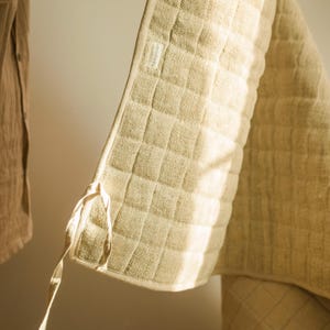 Hemp yoga mat partially unrolled against a clean white wall, displaying raw texture and organic build. Durable, toxin-free, and biodegradable—crafted for natural wellness.
