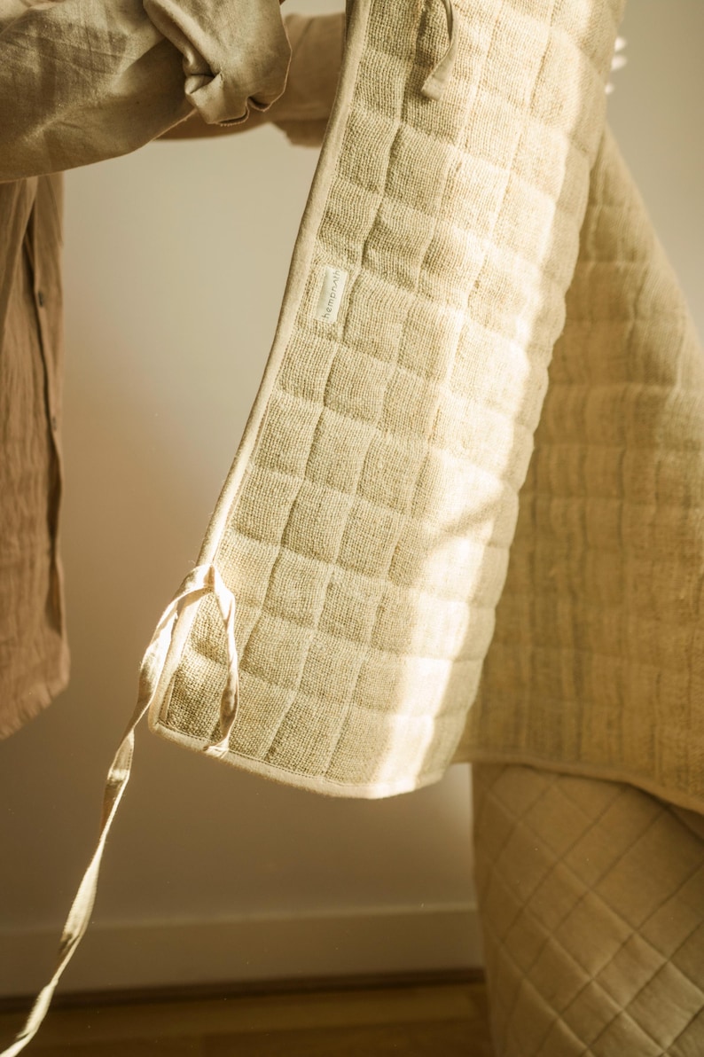 Hemp yoga mat partially unrolled against a clean white wall, displaying raw texture and organic build. Durable, toxin-free, and biodegradable—crafted for natural wellness.