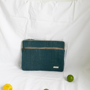 Eco-friendly hemp laptop sleeve in blue, designed to fit 13-inch and 15-inch laptops. Features a minimalist, sustainable design with two spacious compartments for accessories.