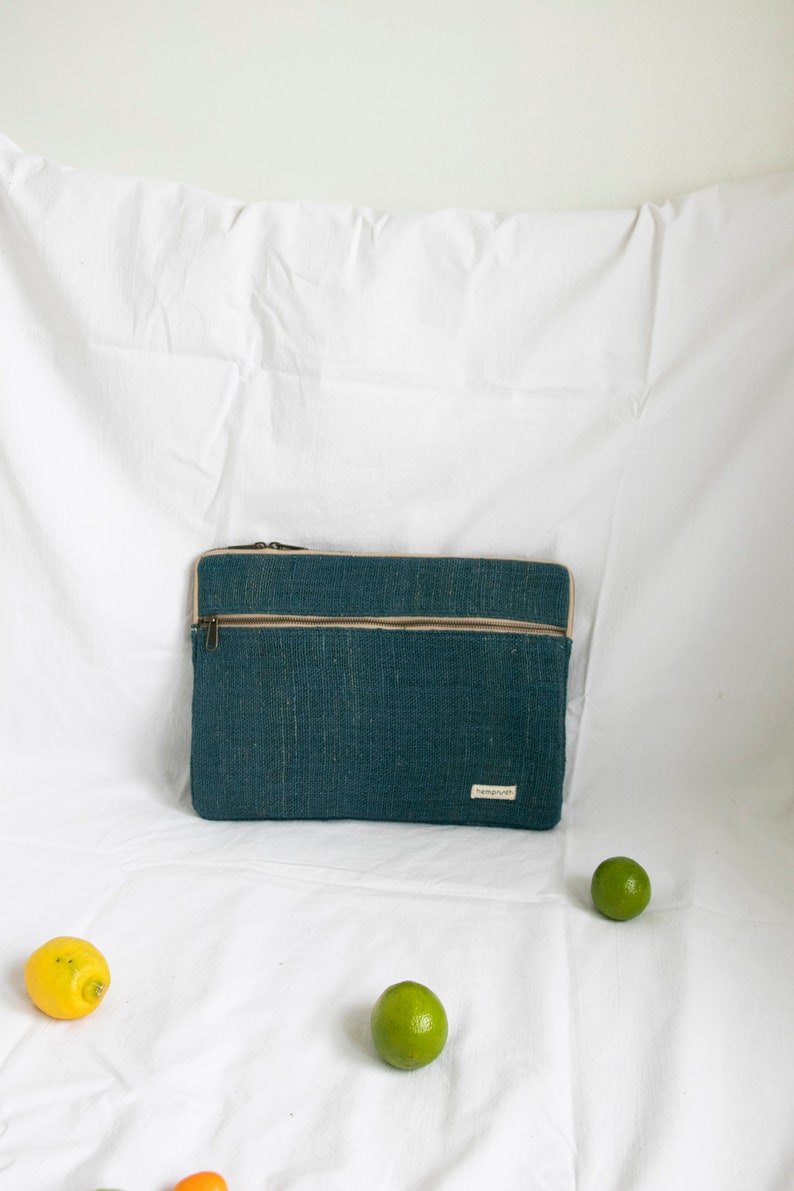 Eco-friendly hemp laptop sleeve in blue, designed to fit 13-inch and 15-inch laptops. Features a minimalist, sustainable design with two spacious compartments for accessories.