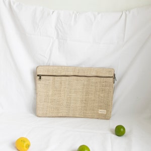 Eco-friendly hemp laptop sleeve in natural beige, designed to fit 13-inch and 15-inch laptops. Features a minimalist, sustainable design with two spacious compartments for accessories.
