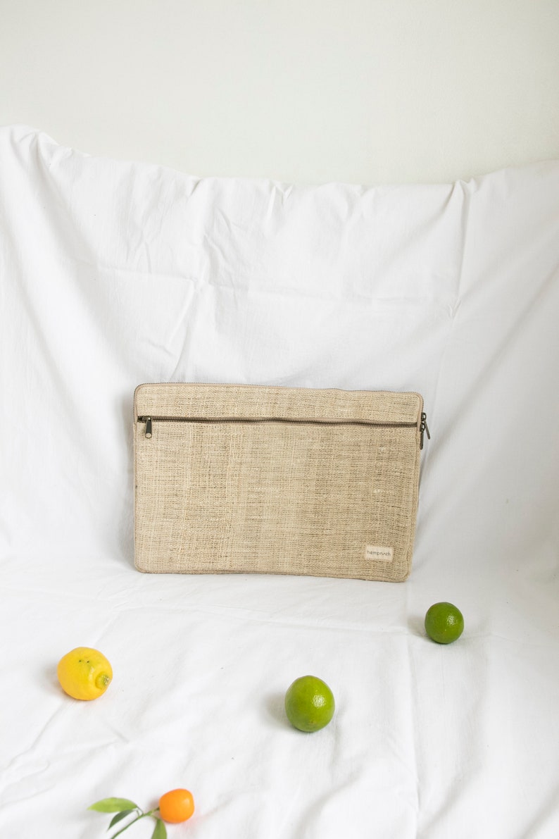 Eco-friendly hemp laptop sleeve in natural beige, designed to fit 13-inch and 15-inch laptops. Features a minimalist, sustainable design with two spacious compartments for accessories.