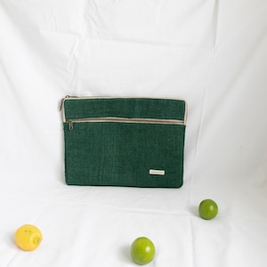 Eco-friendly hemp laptop sleeve in  green, designed to fit 13-inch and 15-inch laptops. Features a minimalist, sustainable design with two spacious compartments for accessories.