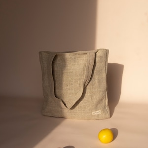 Eco-friendly natural hemp tote bag in beige, featuring a spacious design with durable handles. Perfect for zero-waste shopping, daily errands, or casual outings