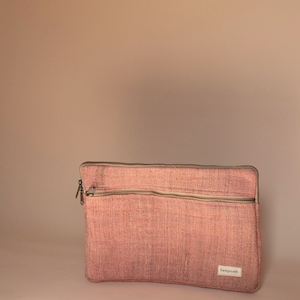 Eco-friendly hemp laptop sleeve in pink designed to fit 13-inch and 15-inch laptops. Features a minimalist, sustainable design with two spacious compartments for accessories.
