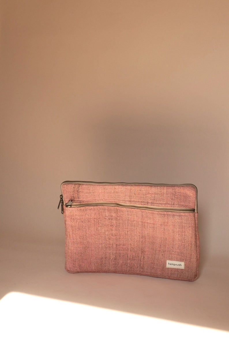 Eco-friendly hemp laptop sleeve in pink designed to fit 13-inch and 15-inch laptops. Features a minimalist, sustainable design with two spacious compartments for accessories.