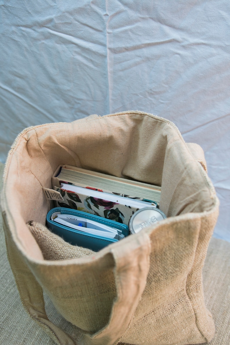 Close-up of the natural hemp fabric on the tote bag, highlighting the what can fit inside the spacious tote bag