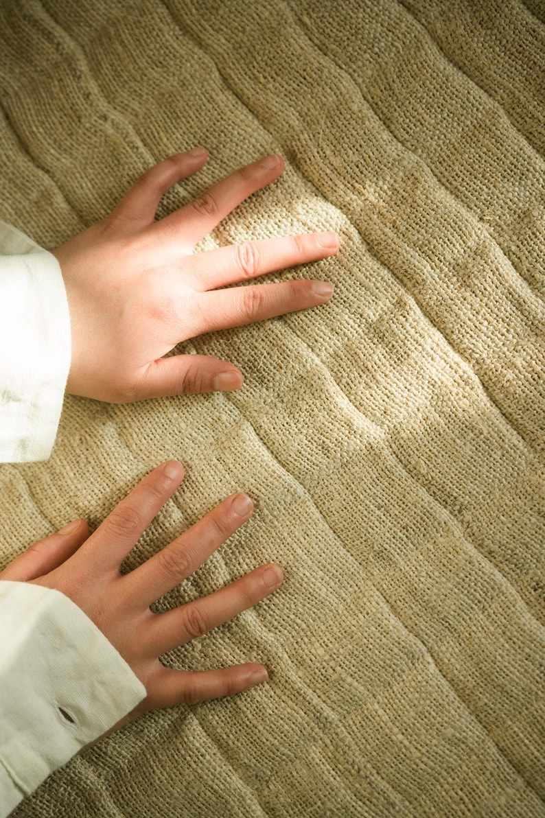 close up of the natural yoga mat with hands placed on it