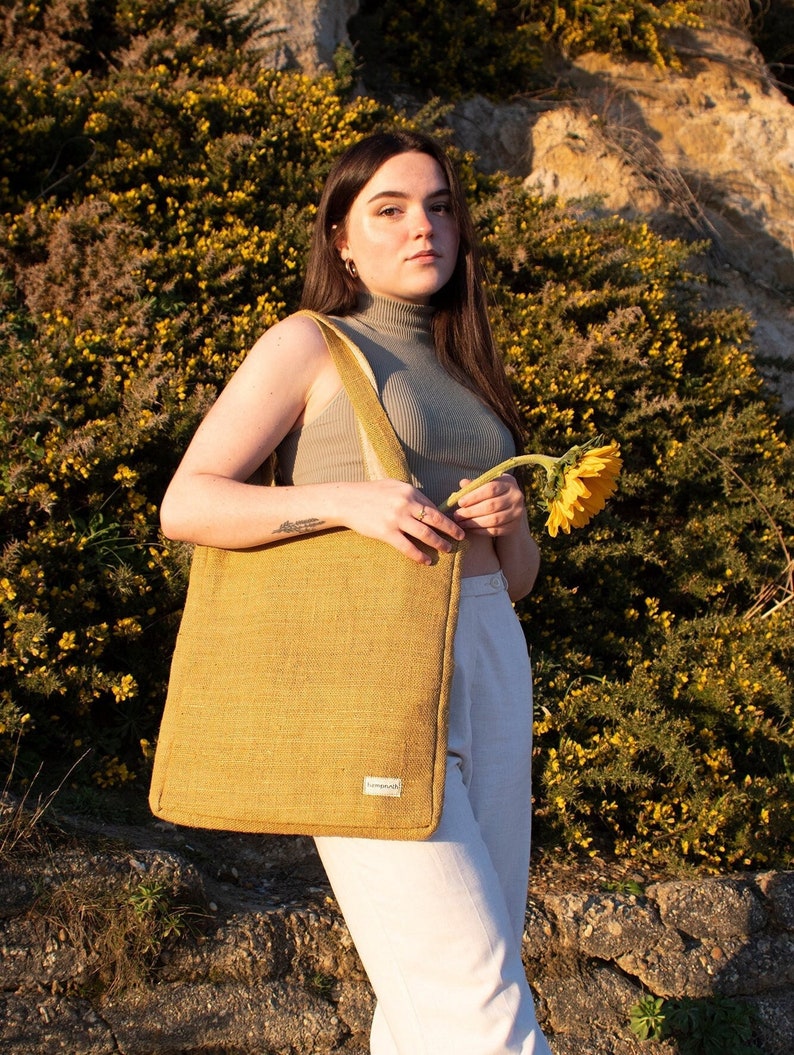 Person carrying the natural hemp tote bag in mustard during a casual day out
