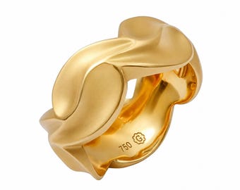 Puede incluir: Un anillo de oro con una banda ancha de diseño ondulado. La superficie presenta un acabado mate y suave en las curvas exteriores. El interior de la banda está claramente marcado con el texto 750 y un símbolo G dentro de una forma floral.