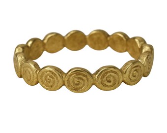 May include: A gold-coloured ring with a repeating spiral design. The ring has a textured surface and a continuous pattern of circular spirals. The ring is a piece of jewellery, likely worn on a finger.