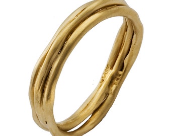 May include: A gold-colored ring with a unique, intertwined design. The ring appears to be made of three bands that twist and overlap, creating a textured, organic look. The ring is set against a white background.